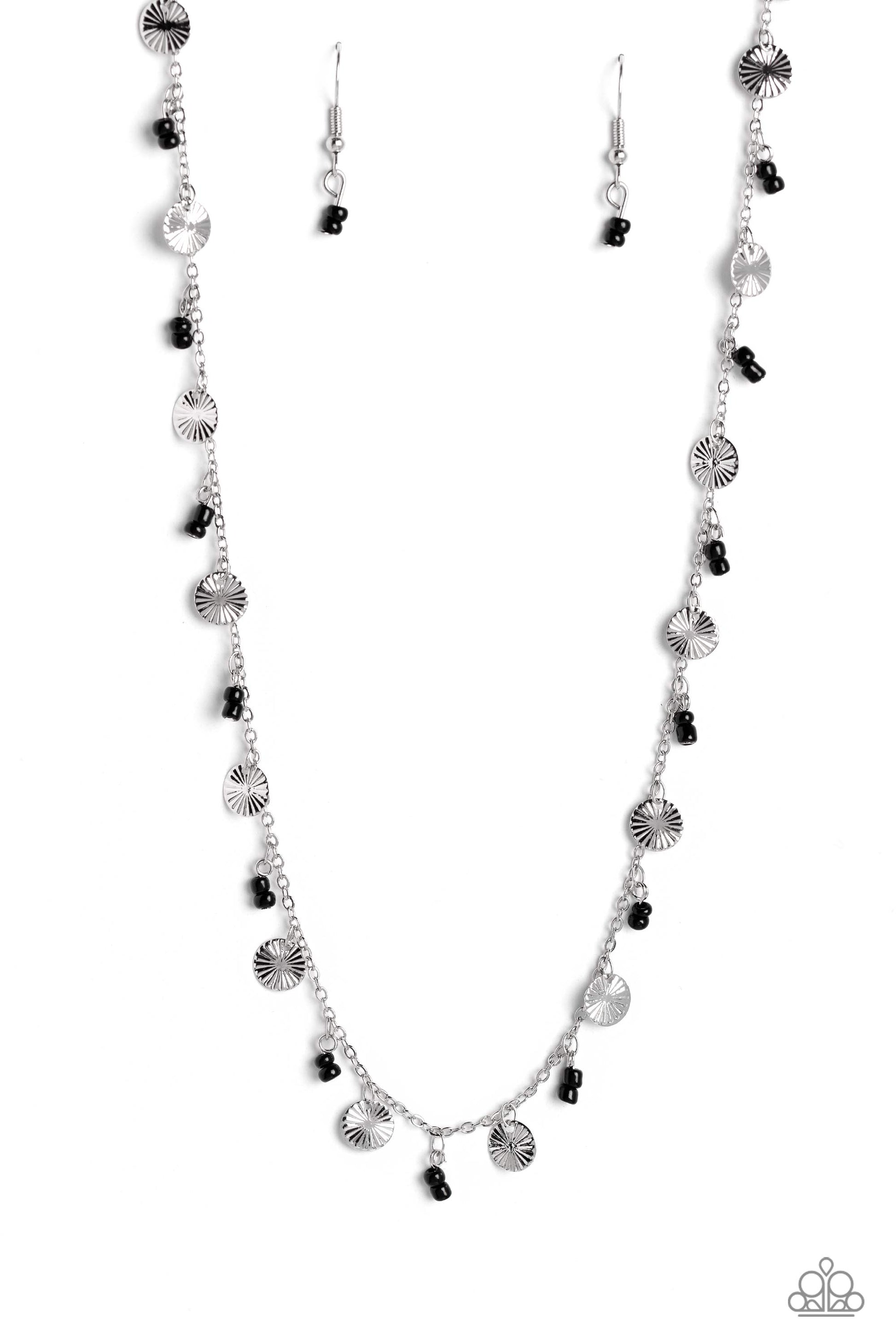 Infused along a dainty silver chain, duos of black seed beads alternate with warped, layered silver discs to make a colorful, sand-dollar-like statement down the neckline. Features an adjustable clasp closure.  Sold as one individual necklace. Includes one pair of matching earrings.