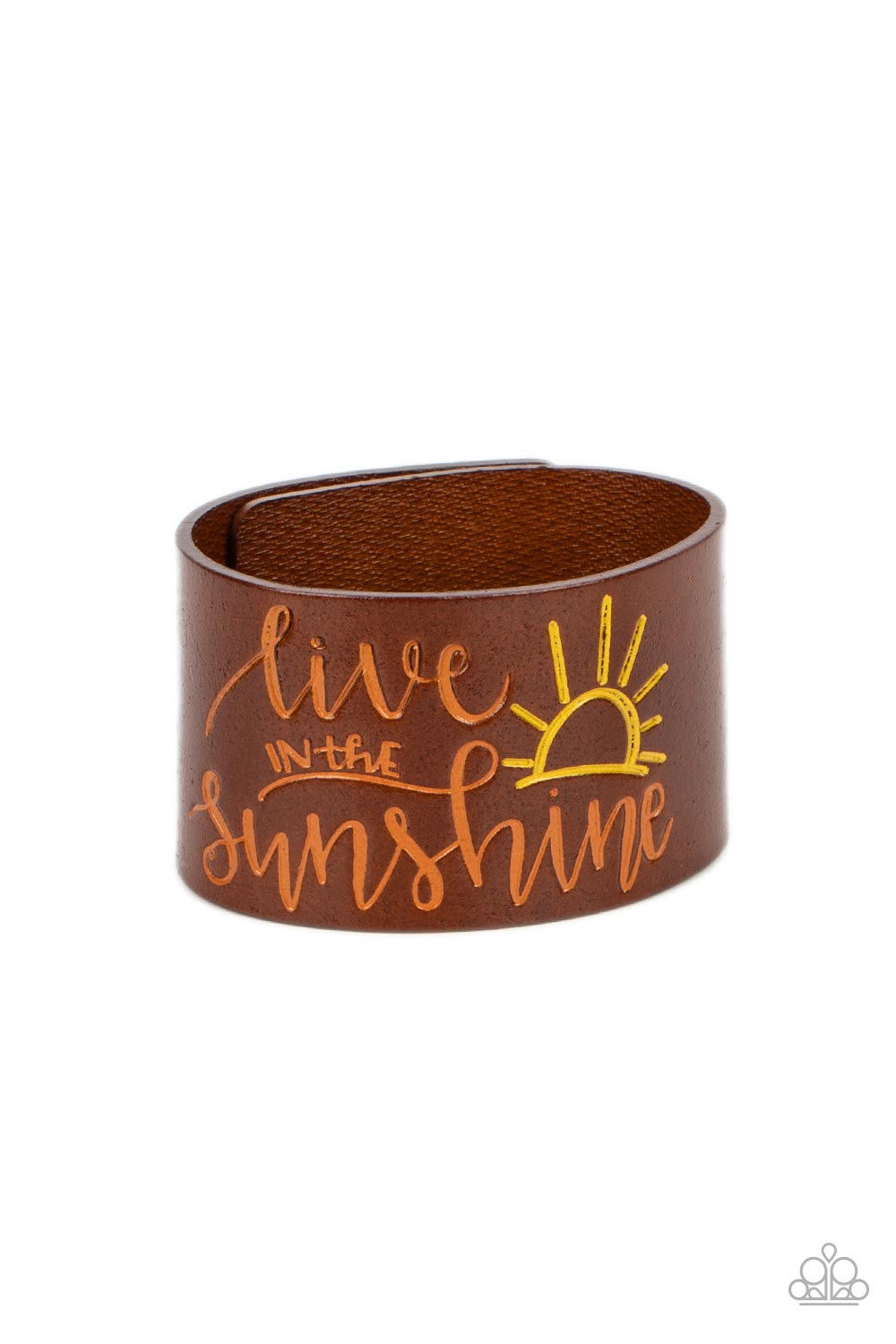 A thick band of light brown leather is stamped with the cheerful phrase, "live in the sunshine," along with a radiating sun design. The orange font complements the yellow tint of the sun in an optimistic finish. Features an adjustable snap closure.  Sold as one individual bracelet.