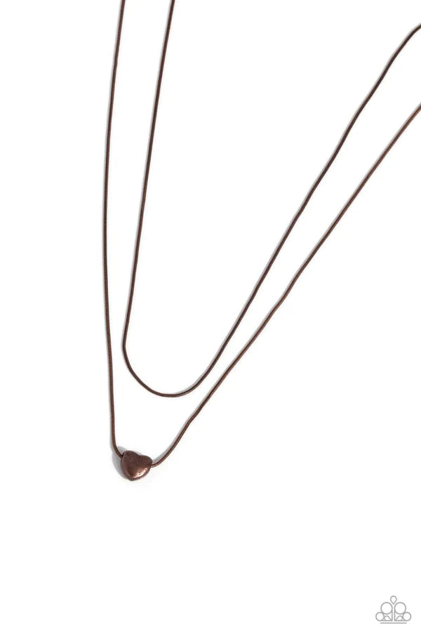 Infused with a dainty copper snake chain, a sleek copper heart charm glides along an additional copper snake chain, creating a stunning layered look. Features an adjustable clasp closure.  Sold as one individual necklace. Includes one pair of matching earrings.