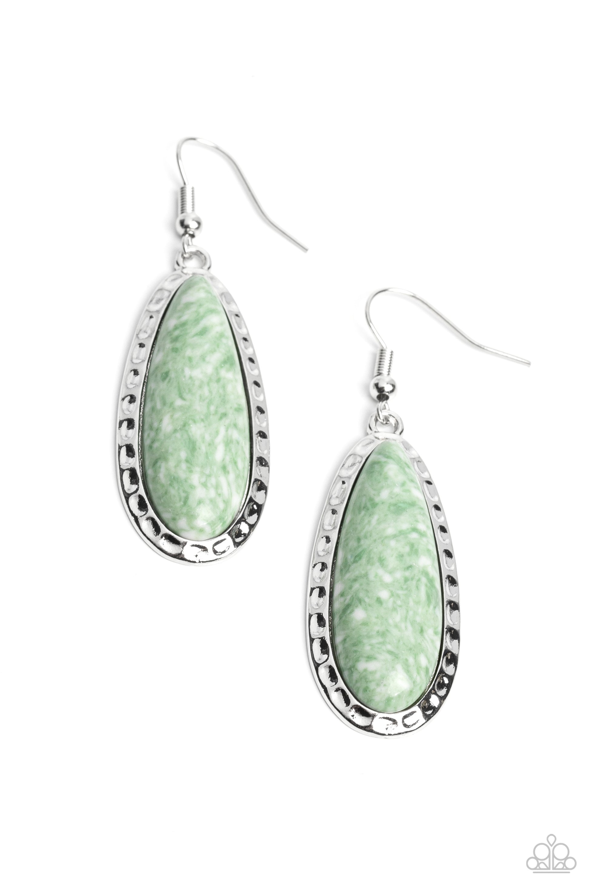 Elongating past the ear, an elongated green teardrop stone, spotted with white accents is pressed into an antiqued-hammered silver frame, creating an earthy statement. Earring attaches to a standard fishhook fitting. As the stone elements in this piece are natural, some color variation is normal.  Sold as one pair of earrings.