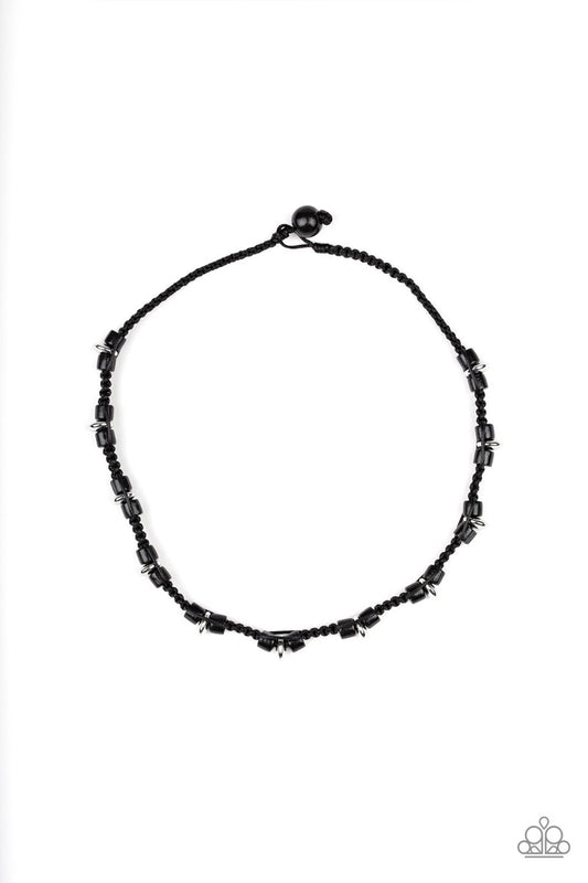Braided cording knots around black wooden and shiny silver beads below the collar for an urban look. Features a button loop closure.  Sold as one individual necklace.